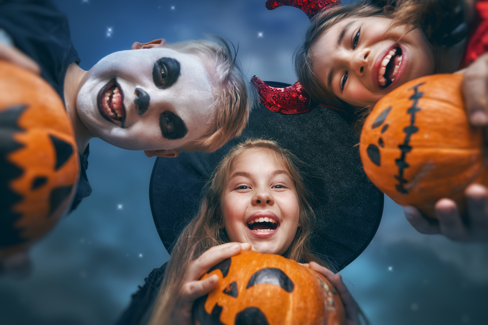 Kids in Halloween costumes with pumpkins