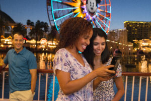 Girls on their phone inside Disney California Adventure Park